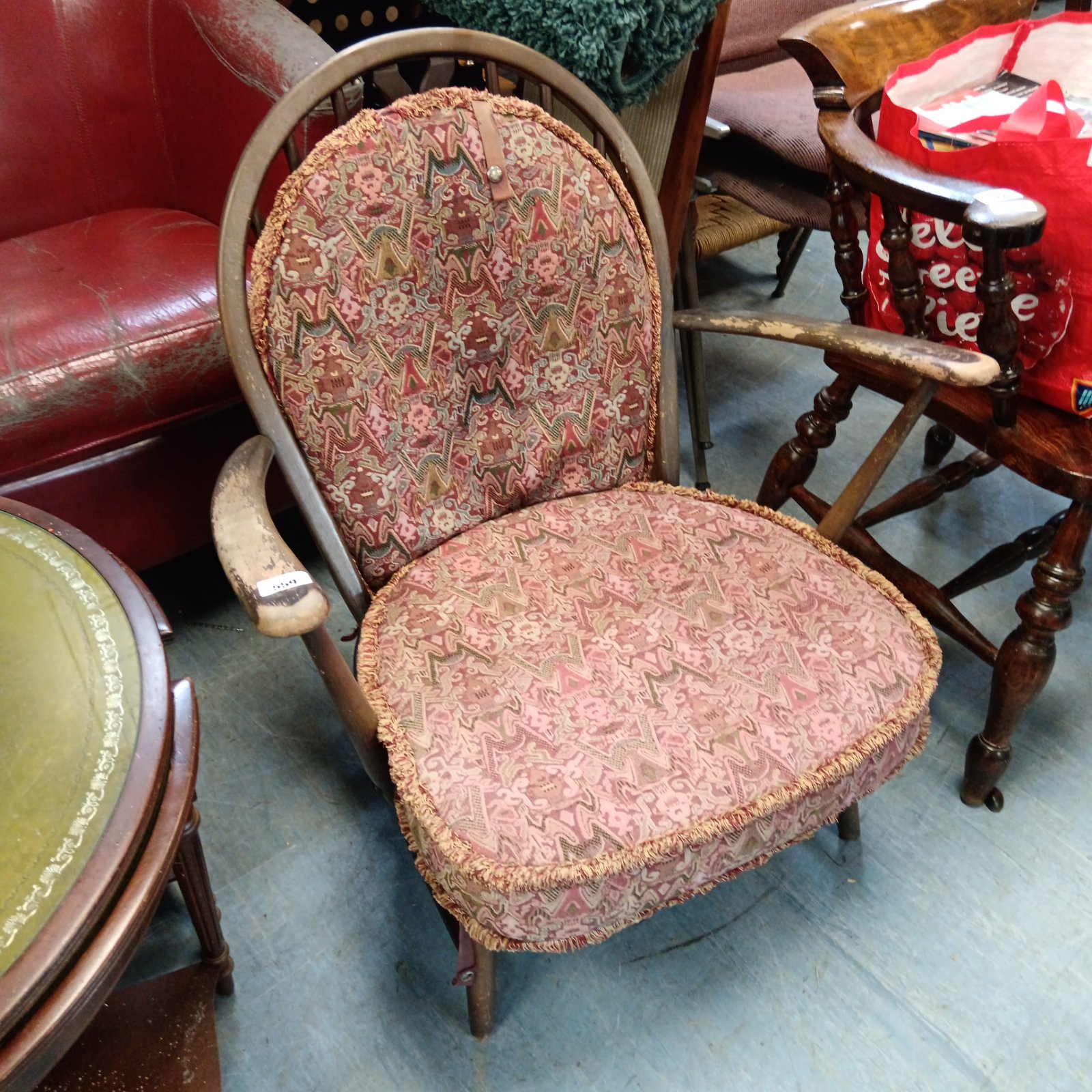 Vintage Ercol armchair with patterned upholstery and stickback design.