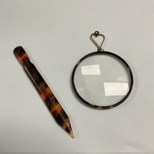 Vintage faux tortoiseshell paper knife beside magnifying glass with heart-shaped loop