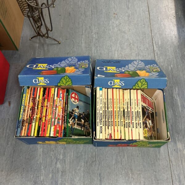 Two boxes of vintage Shoot Annuals and Topical Times Football Books on display