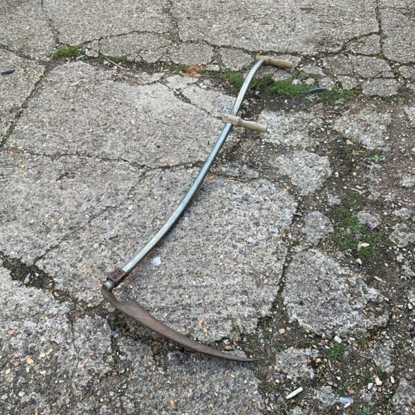 Vintage garden scythe with curved blade and wooden handle.