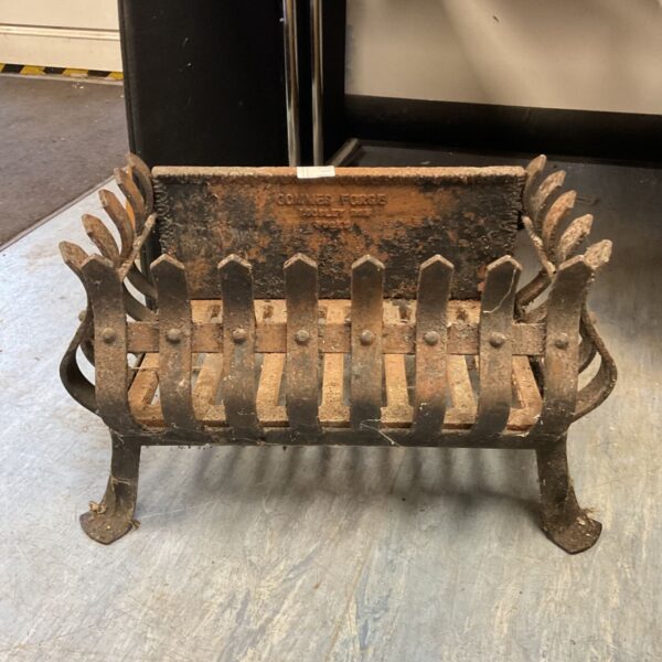 Vintage Gommes Forge fireplace basket with rust and wear on dark metal