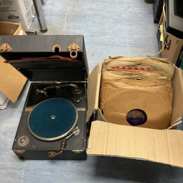 Open vintage Dulcetto gramophone with records nearby.