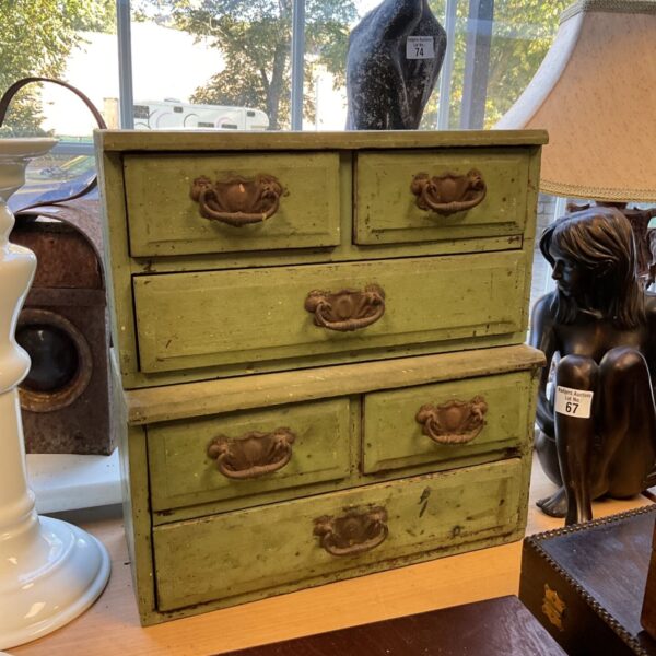 Vintage green desktop drawers for organizing small items.