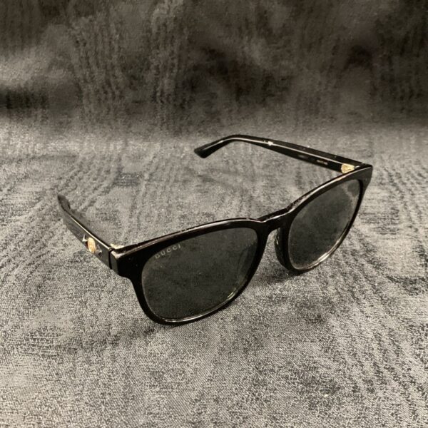 Pair of vintage Gucci sunglasses with black frame and dark tinted lenses