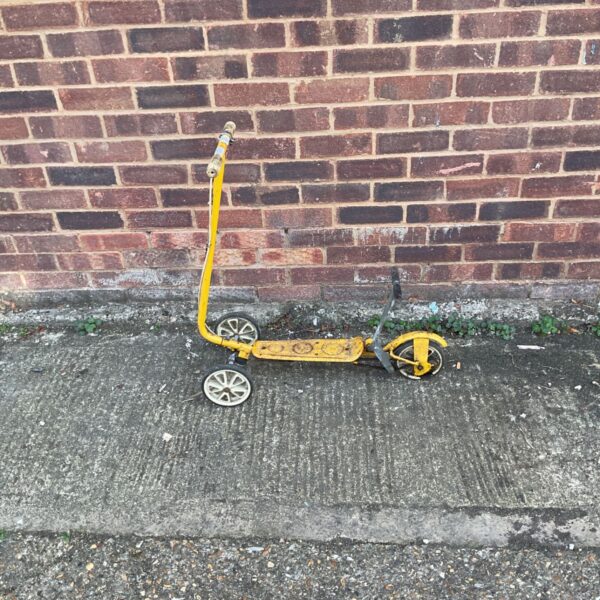 Vintage yellow Honda Kick 'N' Go three-wheel scooter.