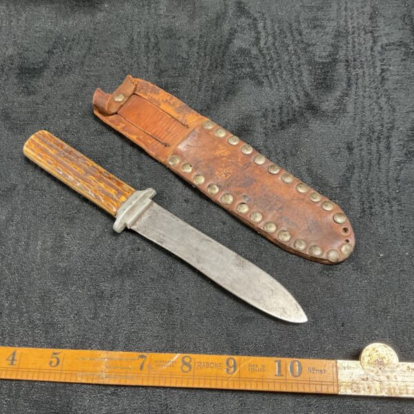 Vintage horn handled knife with leather sheath, collectible blade.