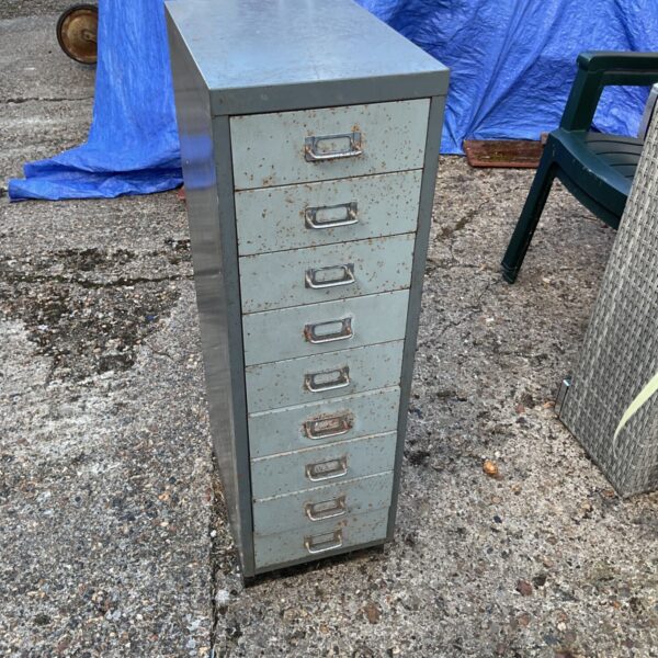 Vintage industrial steel cabinet with multiple drawers, showing wear.
