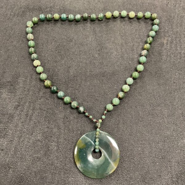 Vintage jade necklace with hand-knotted beads and green pendant.