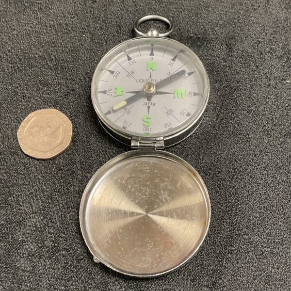 Vintage Japanese pocket compass with liquid fill and degree markings.
