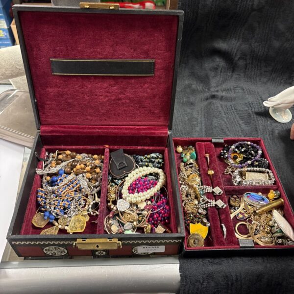 Open vintage jewellery case with burgundy velvet lining and mixed costume jewellery contents