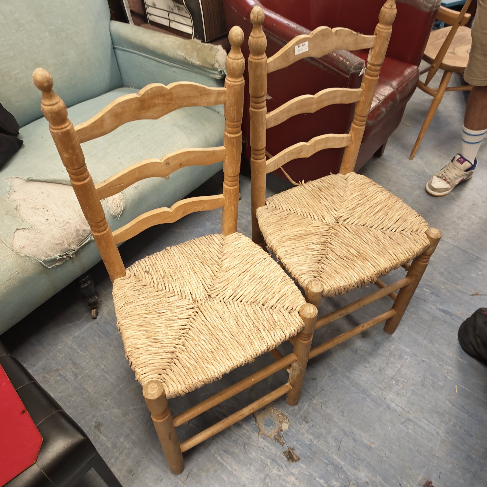 Pair of vintage ladder back chairs with woven rush seats.