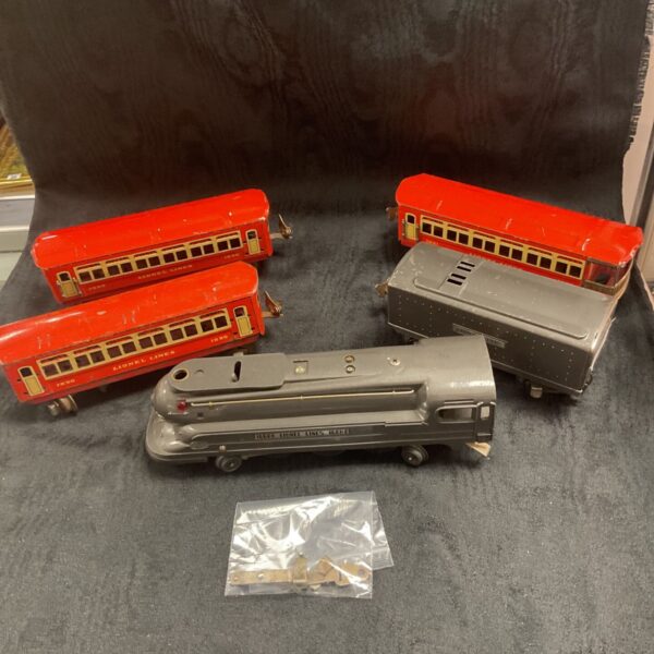 Vintage Lionel train set with red passenger cars and grey locomotive.