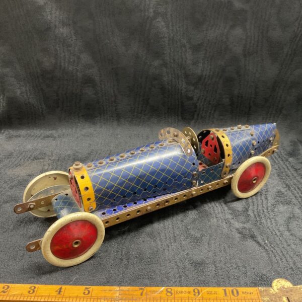Vintage Meccano race car with red wheels and blue body.