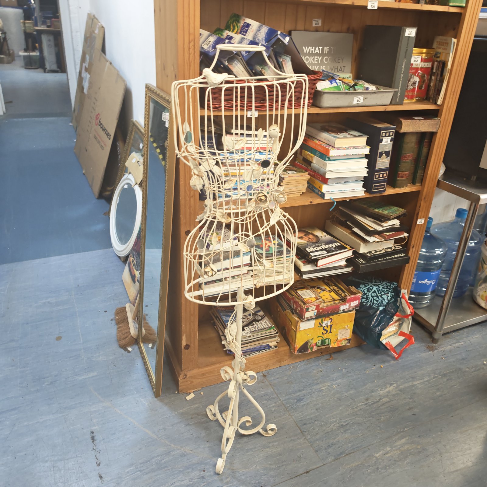 Vintage metal dress form mannequin with books nearby.