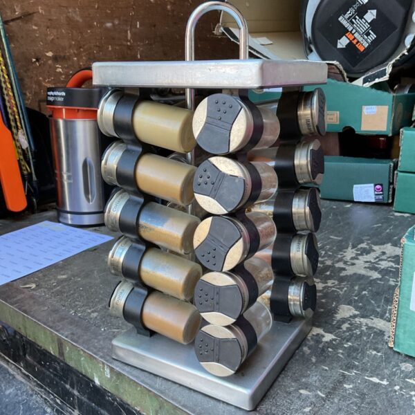 Vintage metal revolving spice rack filled with spices.