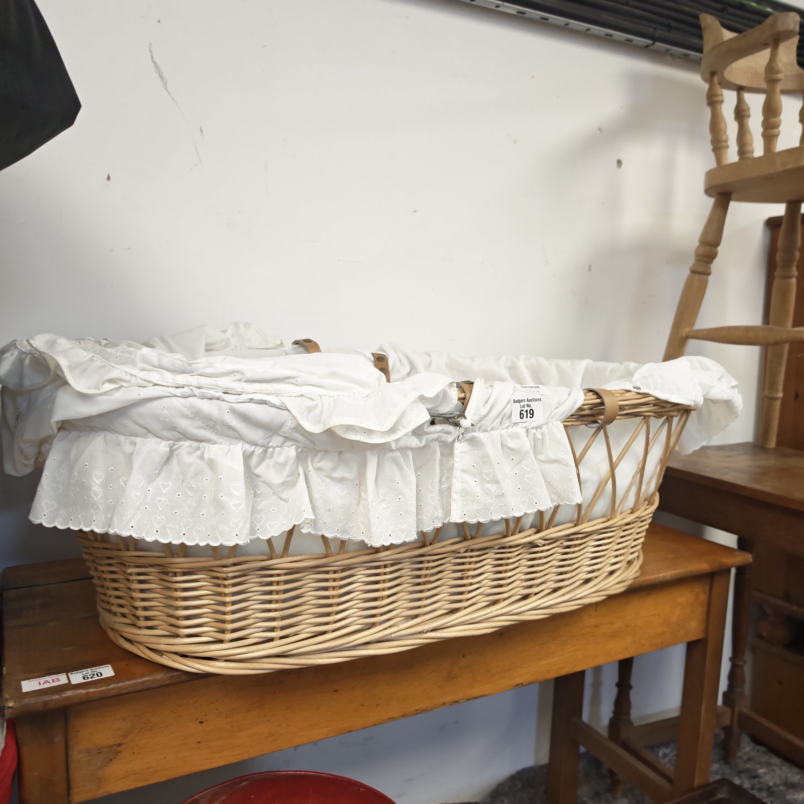 Vintage wicker Moses basket with white lace detailing.