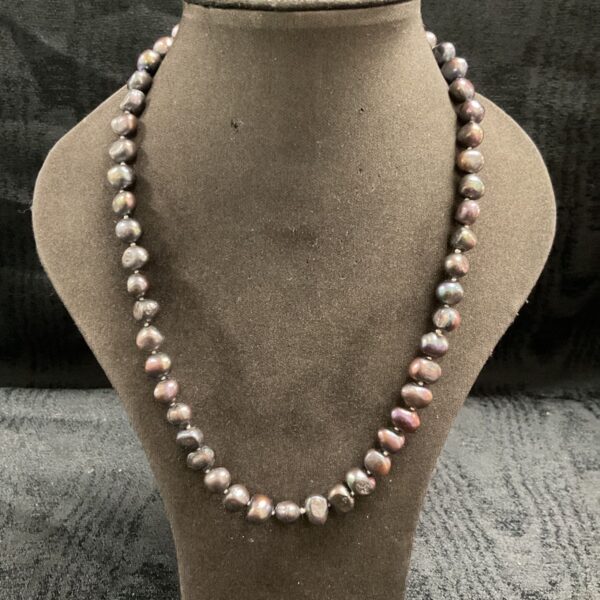 Vintage natural black pearl necklace with knotted irregular pearls on display bust