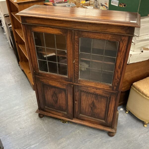 Vintage oak display cabinet with glass doors and key.