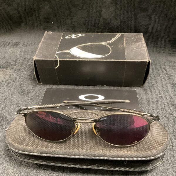 Vintage Oakley sunglasses with original case and box displayed.
