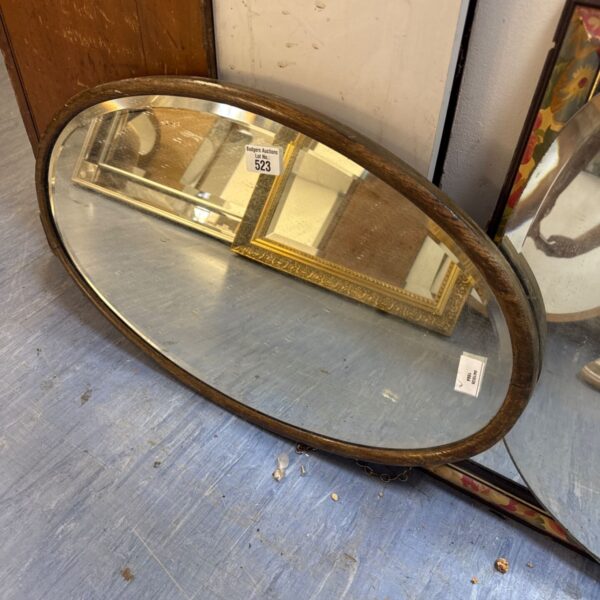 Vintage oval mirror with wooden frame and bevelled glass.