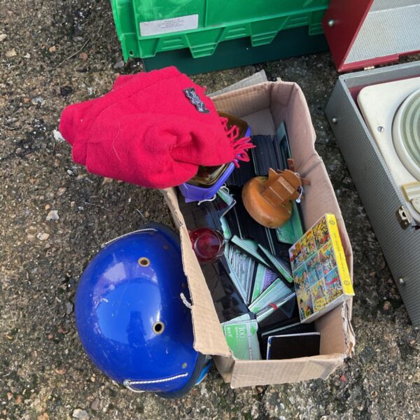 Vintage phone cards and 8mm film in a box beside a blue mountaineering helmet