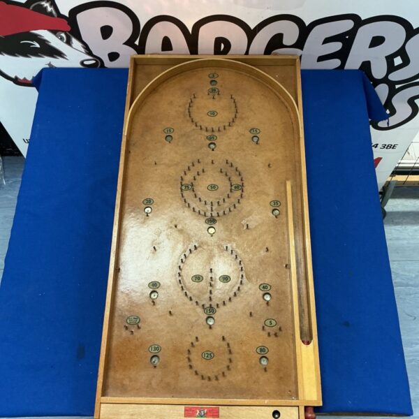 Vintage pinball board with colourful graphics and signs of wear.