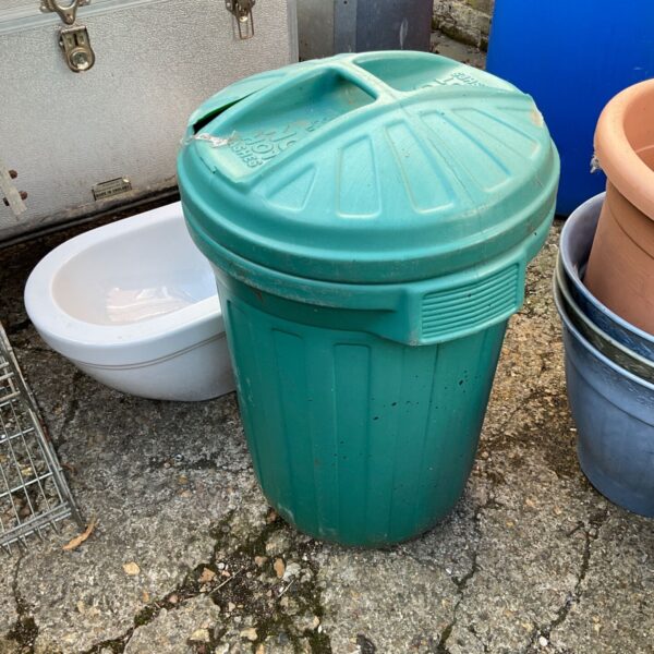 Vintage green plastic dustbin, a collectible garden item.