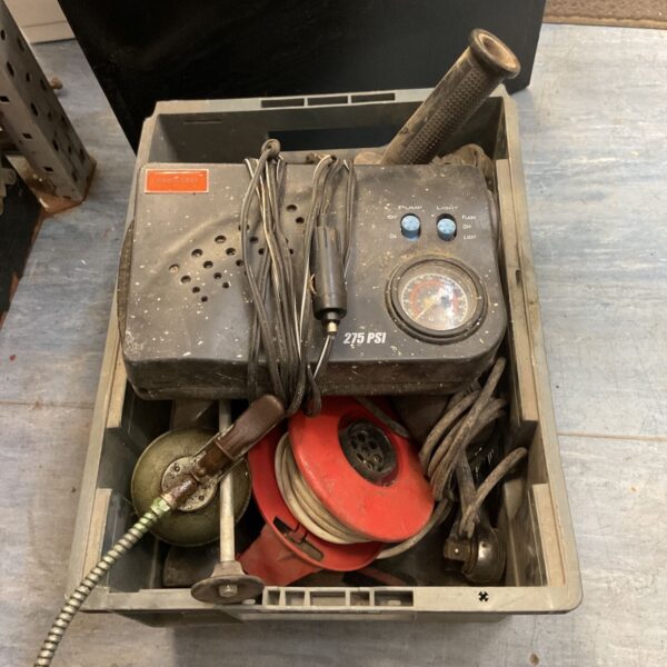 Vintage portable air compressor with tools inside a metal case.