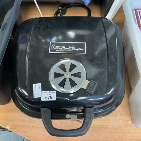 Vintage portable charcoal BBQ grill with a red handle.