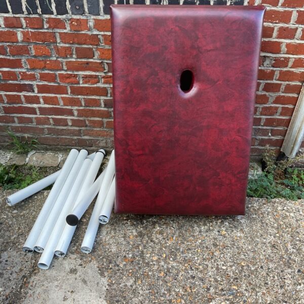 Vintage red massage chair with legs, a collectible furniture piece.