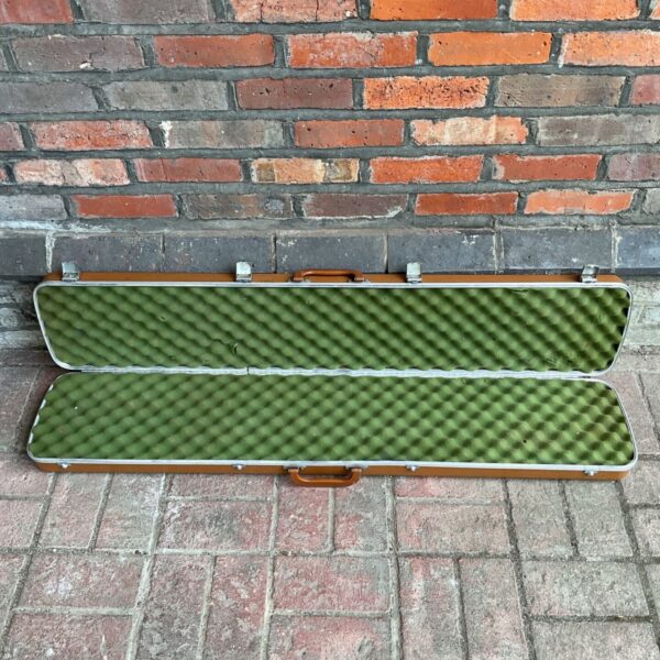 Open vintage rifle case with green padded interior.