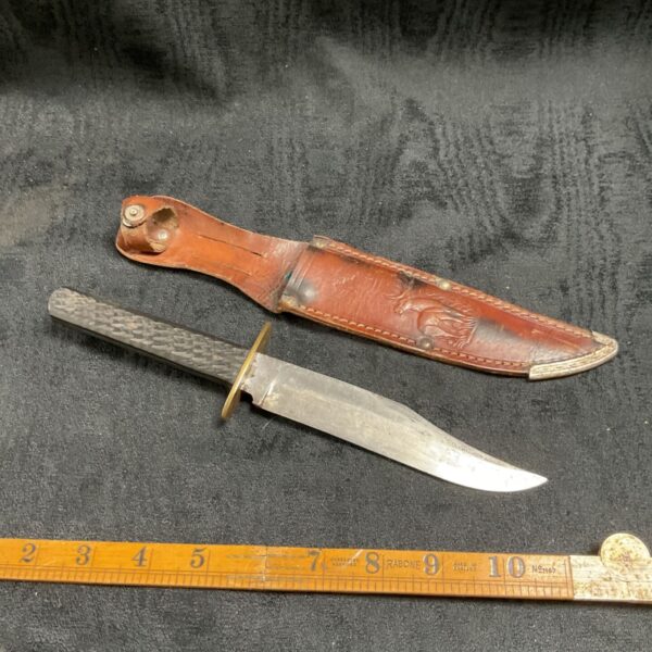 Vintage sheath knife with leather sheath, showing blade and handle.