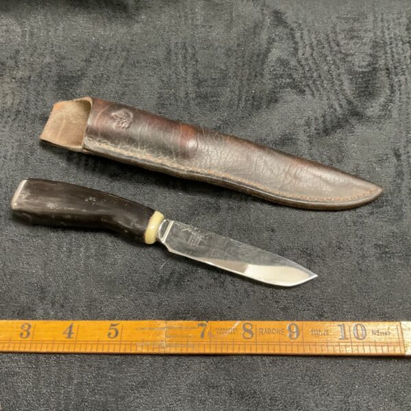 Vintage sheath knife with bone handle and leather sheath.