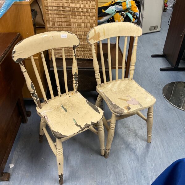 Pair of vintage stick back chairs with chipped paint.