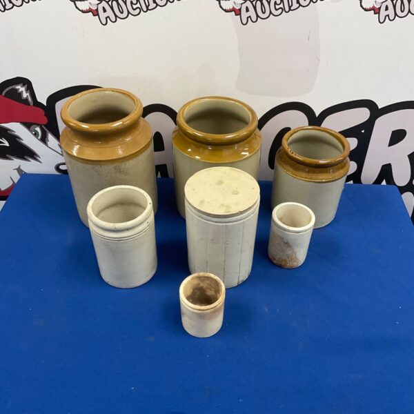 Selection of vintage stoneware salt glazed storage jars on a blue surface