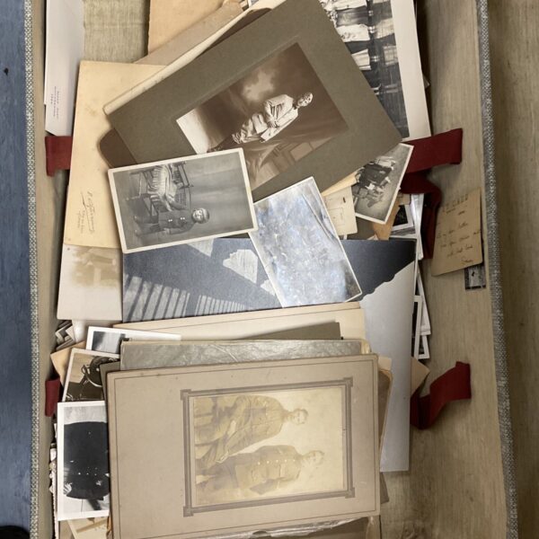 Vintage suitcase containing assorted photographs including military portraits and loose prints