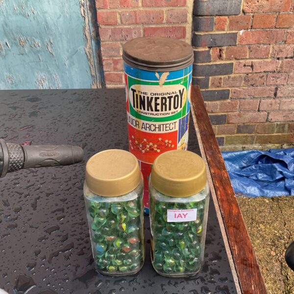 Tinkertoy Junior Architect construction set tin beside two jars of green marbles