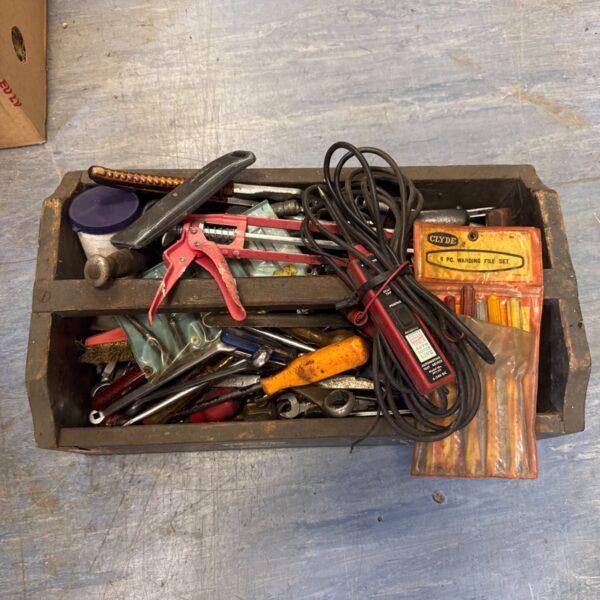 Vintage wooden tool tray filled with antique hand tools.