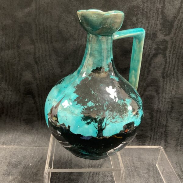Vintage turquoise and black ceramic ewer with night scene.