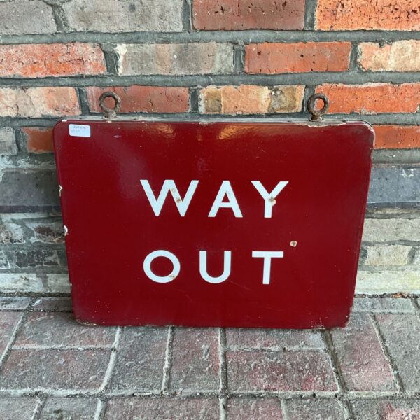 Vintage red enamel Way Out hanging sign with white lettering against brick wall