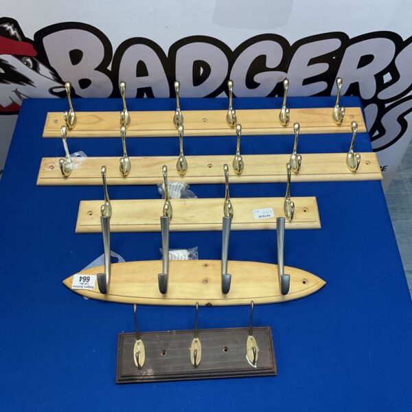 Vintage wooden rack with brass hooks for display.