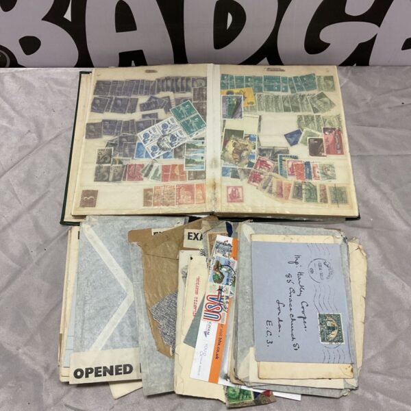 Open vintage stamp album with worldwide stamps beside airmail envelopes