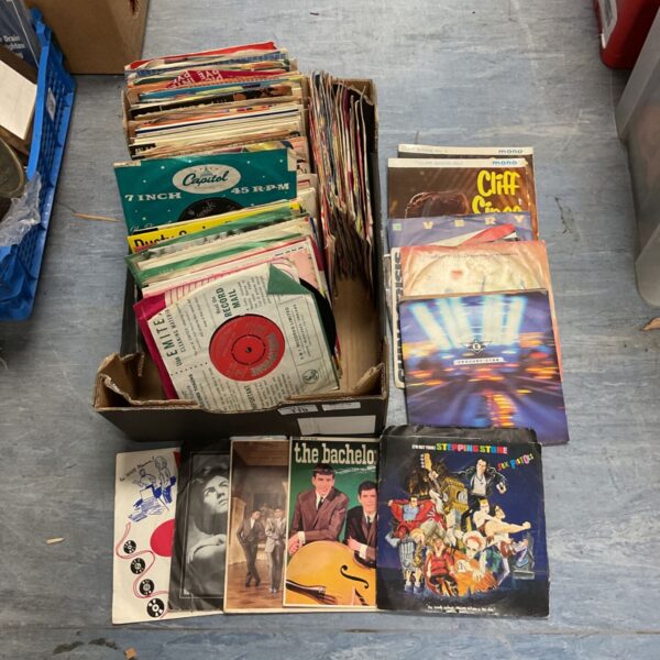 Stack of vintage 7 inch vinyl records including Sex Pistols.