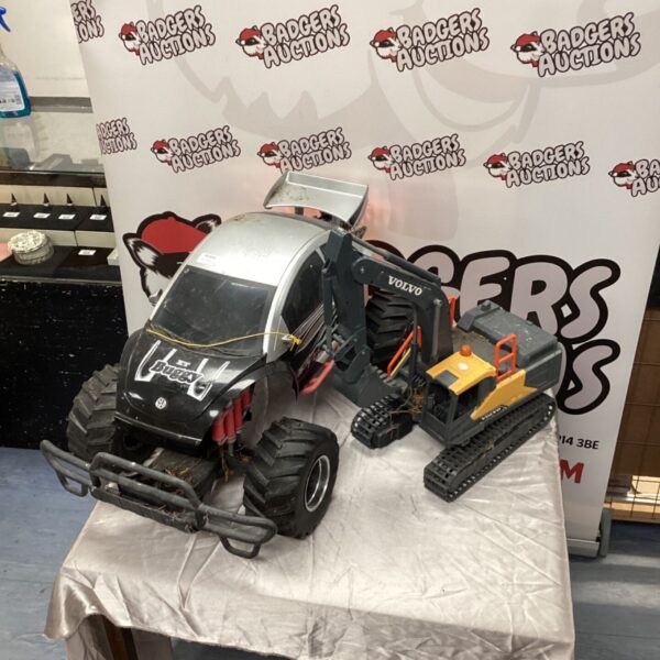 VW XT Buggy toy beside a Volvo digger toy on a table