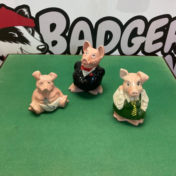 Three Wade pottery NatWest piggy banks in pink glaze, one in black tailcoat