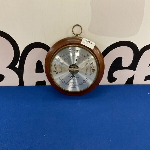 Antique Weathermaster barometer showing dial with weather indications.
