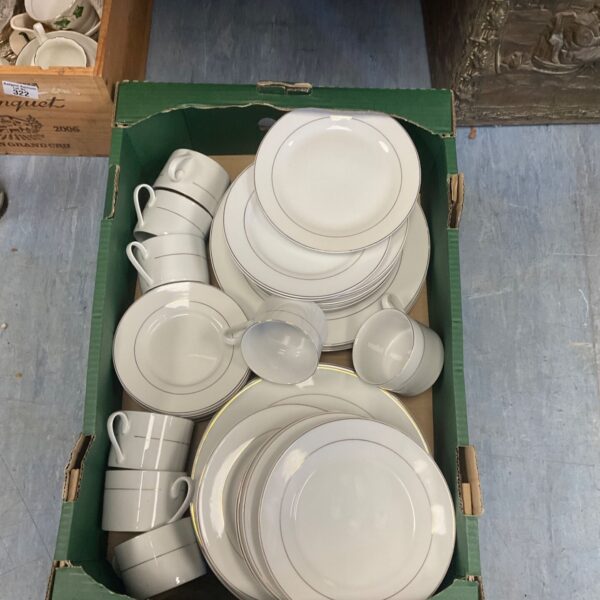 White dinner set with gold trim in a green cardboard box