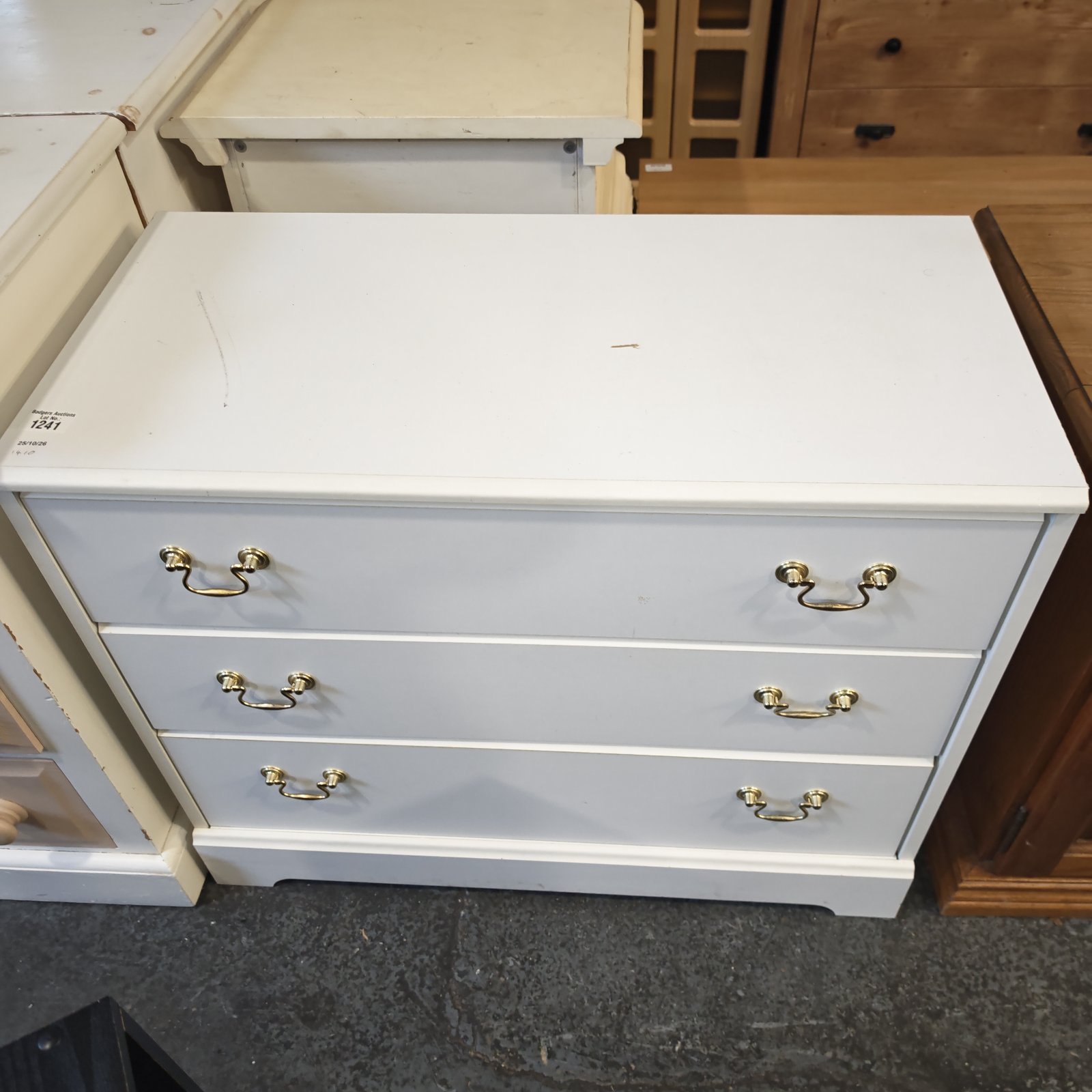 White painted three drawer chest of drawers with brass-coloured drop handles
