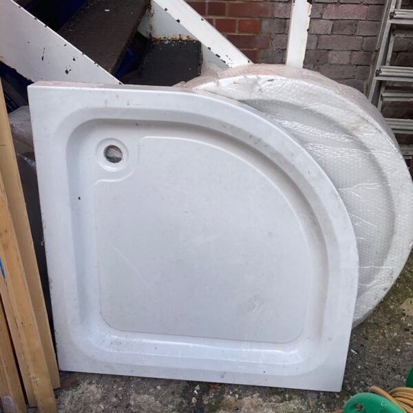 White acrylic shower tray with curved edge, ready for installation.
