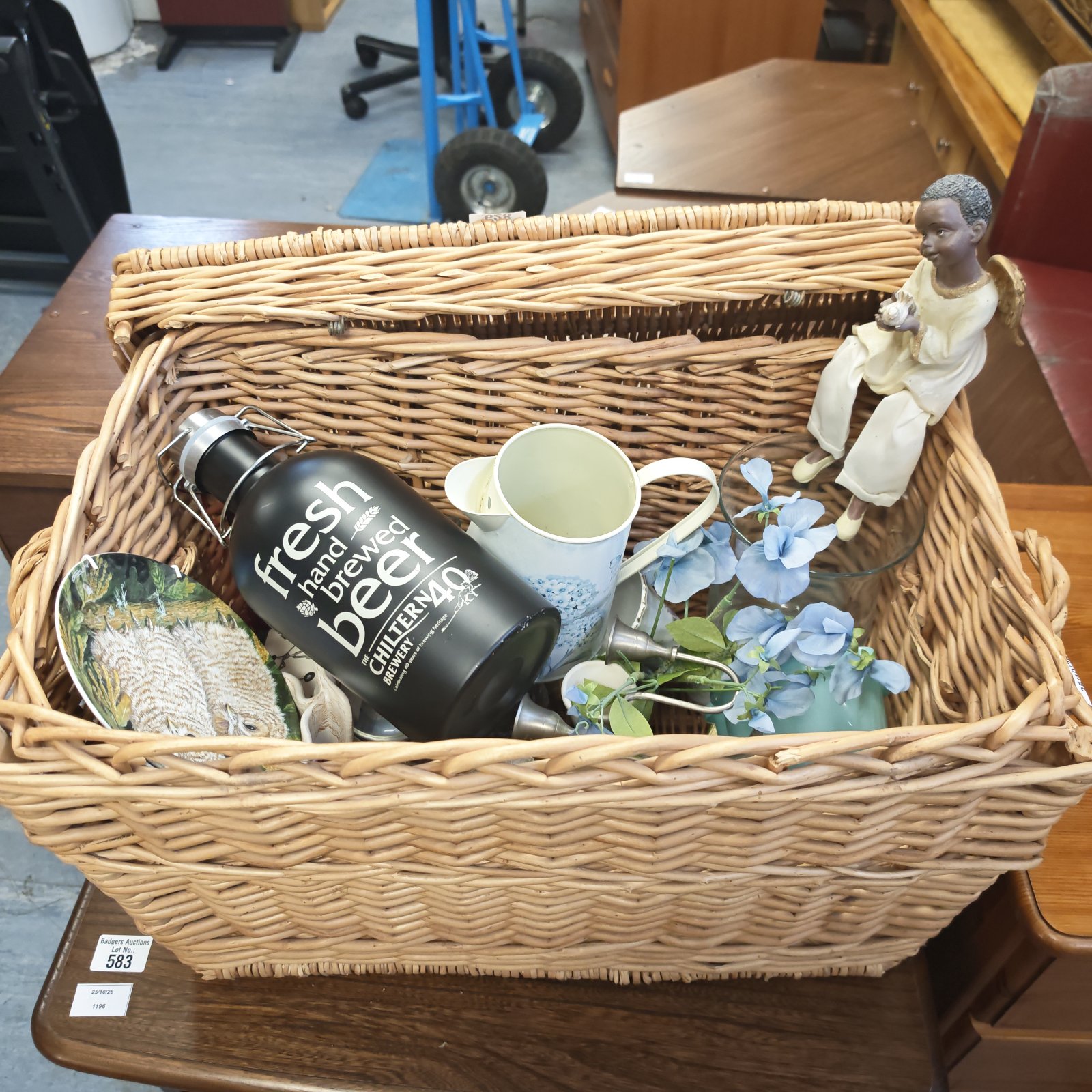 Wicker basket of mixed house clearance items with Chiltern Brewery flask and child ornament